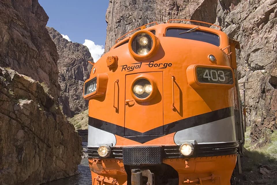 Front view of orange Royal Gorge Route locomotive 403 between canyon walls